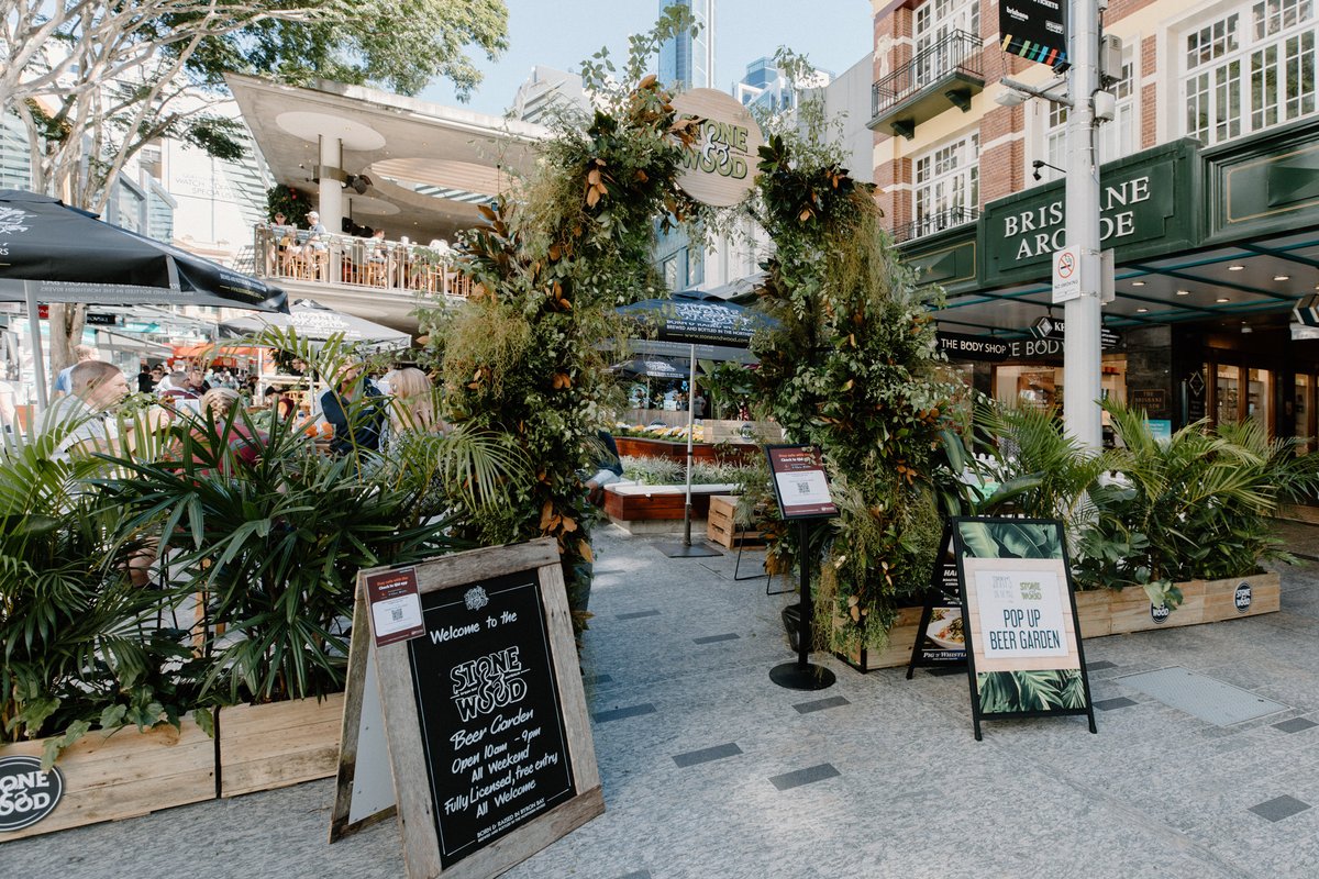 A Stone & Wood pop-up beer garden activation with a lush plant archway in Brisbane CBD