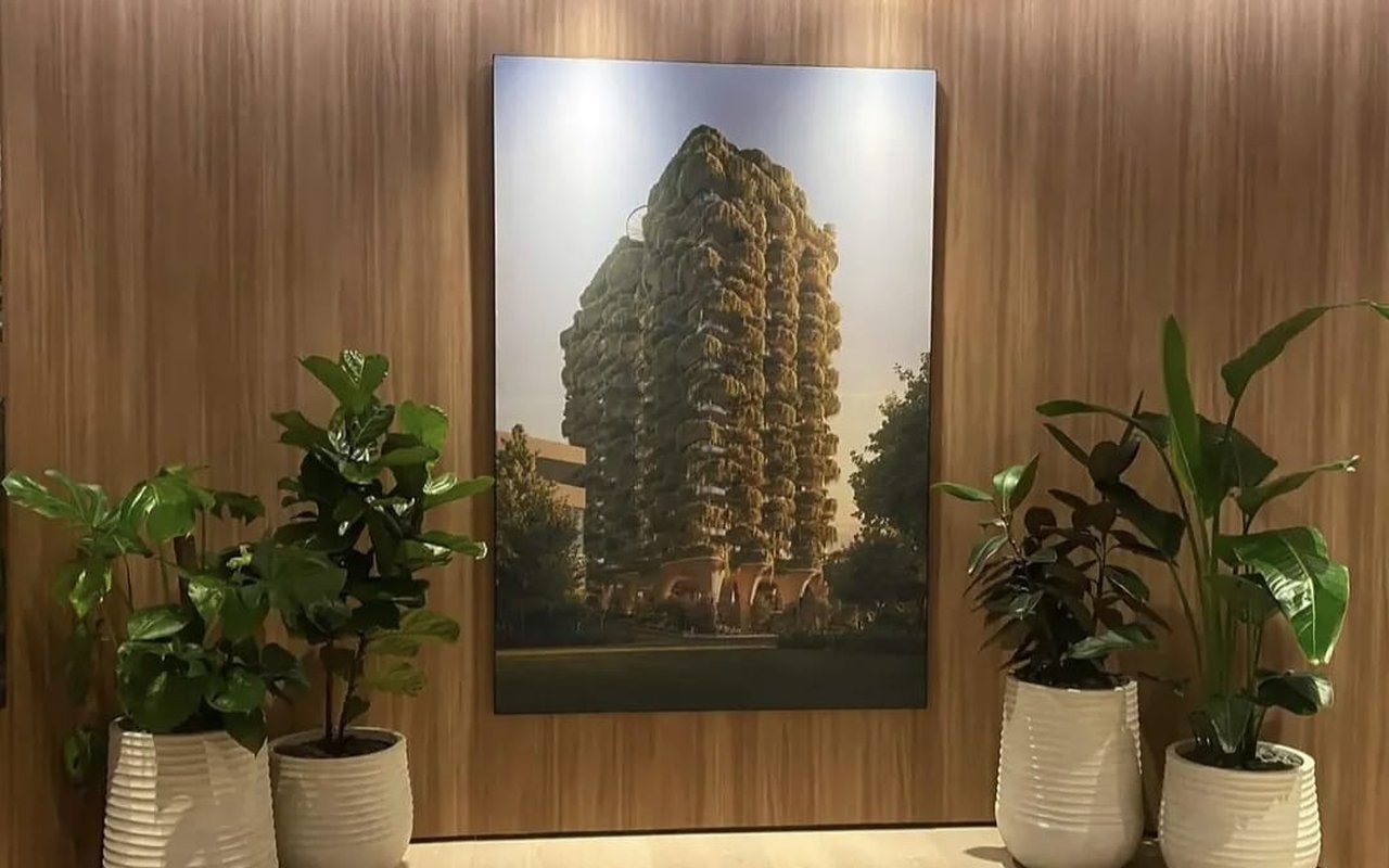 A sales display suite curated with four white planters and a rendering of a green-clad apartment tower